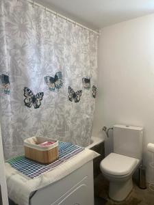a bathroom with a toilet and butterflies on the shower curtain at Cozy house by the sea in Batsi