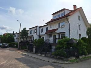 a white house on the side of a street at Stylish 4BR Artist's Home with Garden- Gdańsk Green District by AVALON ATELIER in Gdańsk