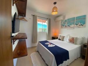 a bedroom with a bed and a flat screen tv at Kailua apartamentos e suítes in Porto De Galinhas