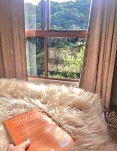 グアラミランガにあるCasa Florença Guaramirangaの大きな窓と毛皮のソファのある部屋