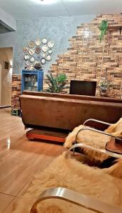 グアラミランガにあるCasa Florença Guaramirangaのレンガの壁の前に浴槽があるリビングルーム