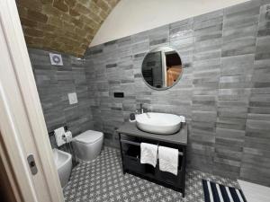a bathroom with a sink and a toilet and a mirror at La casina di Soccorsa in Poggio Imperiale