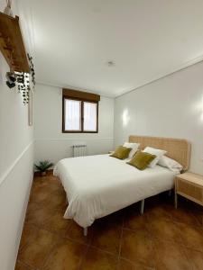 ウスルビルにあるApartamento con jardin y parking privadoの大きな白いベッドと窓のある寝室