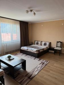 a bedroom with a bed and a table and a couch at Вили Елеганс Сърница in Sarnitsa
