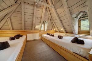 a large room with two beds in a attic at Casa Montlude - Elegancia rústica y confort moderno en el corazón del Valle de Arán by Eth Flòc in Gessa