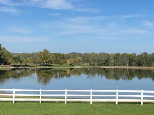 a white fence in front of a lake at Inns at St Albans in Saint Albans