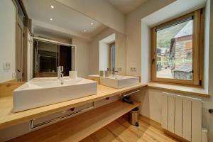 a bathroom with a large white sink and a window at Casa Montlude - Elegancia rústica y confort moderno en el corazón del Valle de Arán by Eth Flòc in Gessa +51 photos