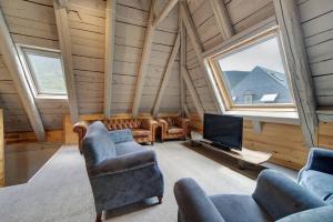 a living room with couches and a tv in a house at Casa Montlude - Elegancia rústica y confort moderno en el corazón del Valle de Arán by Eth Flòc in Gessa