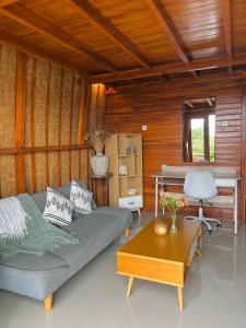 a living room with a couch and a piano at Murna House 1, Rooftop Balinese wooden house 360 sunrise to sunset view in Uluwatu