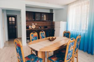 a kitchen with a wooden dining table and chairs at Вила "Роза" in Lakarevo