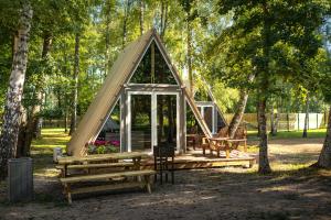 a small tent in a park with benches and trees at Heaven Glamping - 300m from the Beach in Liepāja