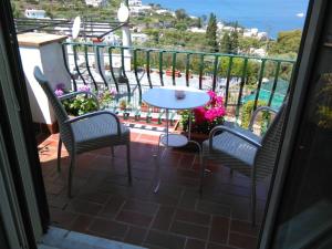 卡普里拉玛克塞拉度假屋的阳台上有两把椅子和一张桌子