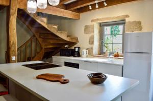 a kitchen with a counter and a white refrigerator at Le Refuge de la Tardes in Champagnat