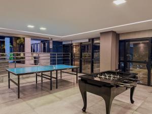 2 mesas de ping pong en una habitación con ventanas en Prédio com excelente custo benefício!, en Maceió