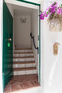 a stairway with a green door and stairs with purple flowers at GreenDoor in Atrani