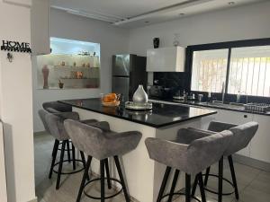 a kitchen with a island with bar stools at Villa in Monastir