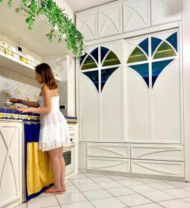 a woman standing at a counter in a kitchen at GreenDoor in Atrani +63 photos