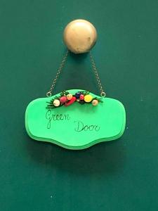 a green door sign hanging on a green table at GreenDoor in Atrani
