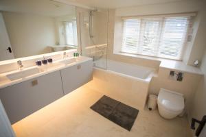 a bathroom with a sink and a tub and a toilet at Craigmoor Cottage, enchanting, tranquil & central in Bourton on the Water