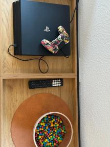 a bowl of gummiobs and a remote control on a shelf at Pro Home FeWo Hiddenhausen in Hiddenhausen