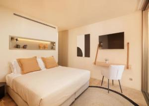 拉戈斯Palmares Signature Apartments的卧室配有白色的床和椅子