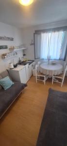 a living room with a table and a table and a kitchen at Apartman Mare BP in Dolac