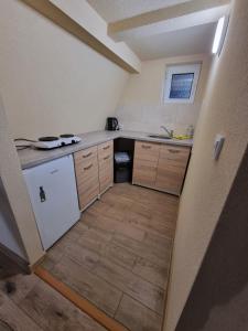 una pequeña cocina con fregadero y lavavajillas en Zatoka Leśna, 