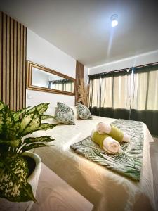 a bedroom with a large bed with pillows and a plant at Serenity Flat in Puerto Tierrabaja +8 photos