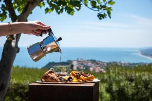 a person is pouring coffee into a plate of food at La Ginestra in Fiore Camere in Sirolo