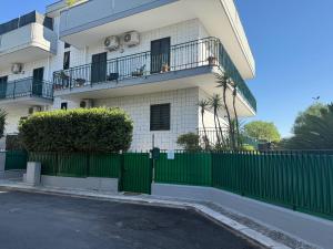 a building with a green fence in front of it at Casa Vacanze Rosie in Cellamare