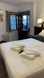 a white bed with two towels on top of it at Hotel del centro in San Martín de los Andes