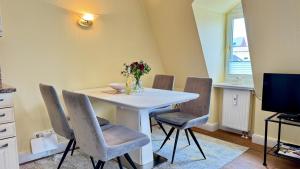 a dining room with a white table and chairs at Syltrose Whg 1b in Westerland (Sylt)