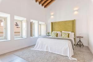 a bedroom with a white bed and white walls at iloftmalaga Premium Centro Histórico in Málaga