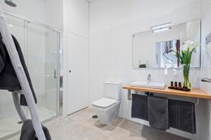 a white bathroom with a toilet and a sink at iloftmalaga Premium Centro Histórico in Málaga