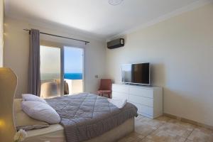 a bedroom with a bed and a tv and a window at Hayah Suites & Rooms in Alexandria