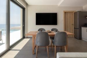 a dining room with a table and chairs and a television at Alon Sevou Boutique Hotel in Syvota