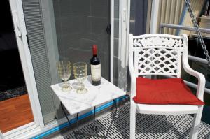 un tavolo bianco con una bottiglia di vino e due bicchieri di A Float Home B&B in Fisherman’s Wharf a Victoria