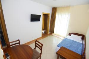 a bedroom with a bed and a table and chairs at Blue Palace Guest House in Budva