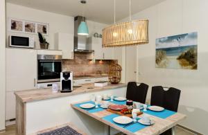 a kitchen with a wooden table with chairs and a dining room at Marina Loft in Kappeln