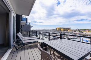 a balcony with a table and chairs and a view of a harbor at Vakantiewoning aan het water - met 4 balkons - Vista Maris - Nr 30 in Sint Annaland