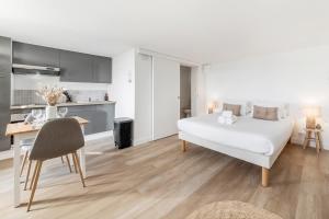 a bedroom with a bed and a desk and a kitchen at Bord de l'eau 2 - Studio - Sea view in Cancale