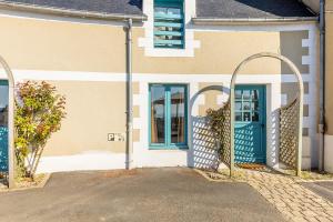 a building with two blue doors and a gate at Bord de l'eau 2 - Studio - Sea view in Cancale +4 photos