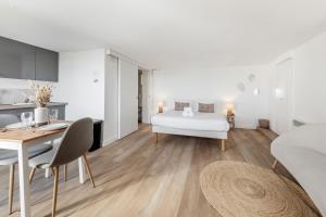 a bedroom with a bed and a table and a kitchen at Bord de l'eau 2 - Studio - Sea view in Cancale