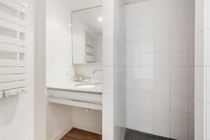 a white bathroom with a sink and a mirror at Bord de l'eau 2 - Studio - Sea view in Cancale
