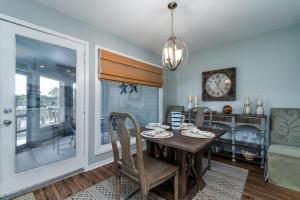 a dining room with a table and chairs and a clock at 1644 Courtside Villa in Seabrook Island