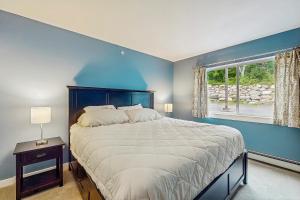 a bedroom with a large bed with a blue wall at Mountainside 75 in Warren +15 photos