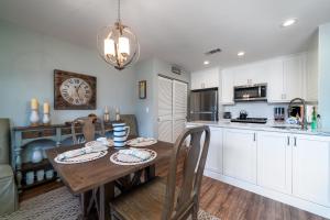 a kitchen with a wooden table and a clock on the wall at 1644 Courtside Villa in Seabrook Island +18 photos