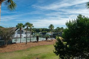 a house on the water with palm trees at 1644 Courtside Villa in Seabrook Island