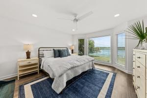 Un dormitorio blanco con una cama y una ventana. en 1935 Bohicket Marina, en Seabrook Island 63 fotos más