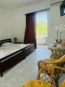 a bedroom with a bed and a table and a window at Hotel Fotini in Mytikas